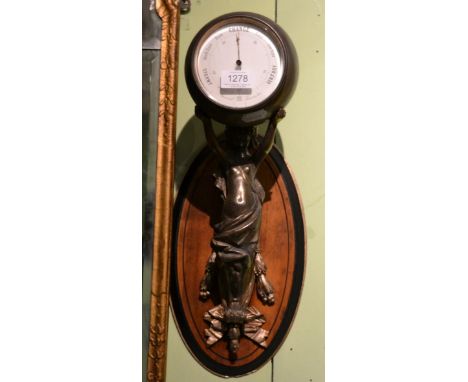 An unusual figural wall mounted aneroid barometer, circa 1900, the maiden figure in robes mounted on a oval wooden wall plaqu