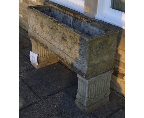 A composition garden rectangular planter, decorated with scrolling flowers and fruit, raised on associated fluted block suppo