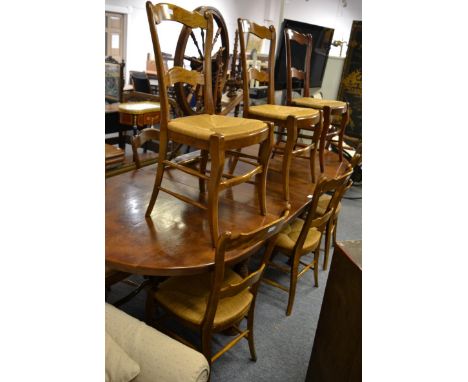 A continental walnut extending dining table with two rounded leaves and two additional leaves, raised on bobbin turned legs a