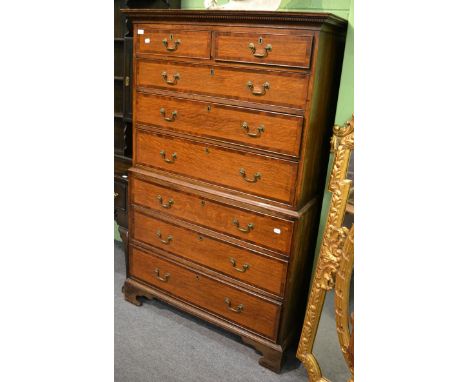 A George III oak and mahogany crossbanded chest on chest, the dentil cornice above two short and three long graduated drawers