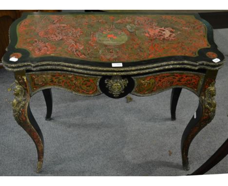A mid-19th century red tortoiseshell and ebonised boulle style fold over card table, with hinged lid enclosing a green velvet
