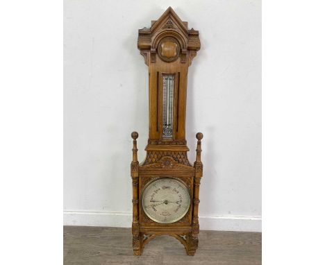 LATE VICTORIAN OAK ANAROID BAROMETER,with silver dials, in carved architectural case with arched pediment over a shield carto