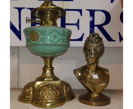 A brass oil lamp with green glass reservoir; a brass bust, female head 