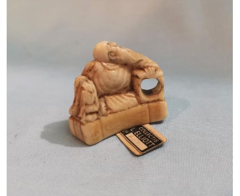 A late 19th / early 20th century Japanese carved Ivory Netsuke depicting a bearded man seated, height 3.5cm with label