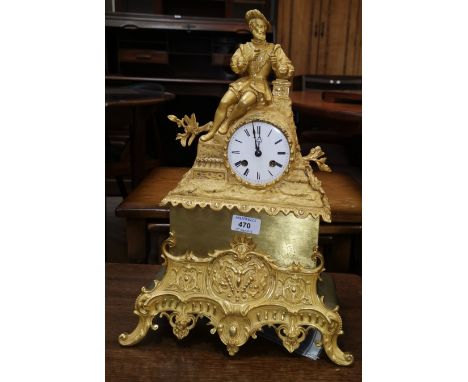 A 19th century French mantel clock in ormolu case, surmounted by reclining man in renaissance dress, white enamel dial and Fr