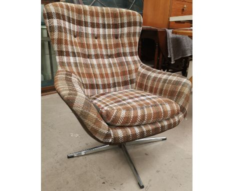 A 1970's egg shaped swivel armchair in brown check, on stainless steel base (sold as a collectors item) 