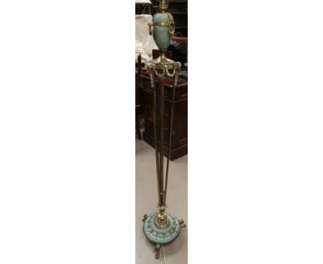 A brass standard lamp with vase terminal and swag decoration on trio support on circular 3 footed base 