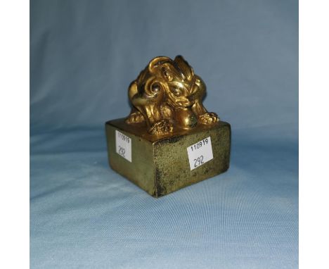 A large Chinese gilt cast metal seal with mythical beast to the top 