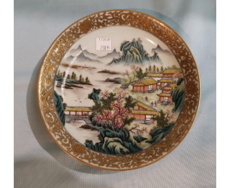 A Chinese Republic shallow dish decorated in polychrome with buildings in river landscape, famille jaune border to the revers