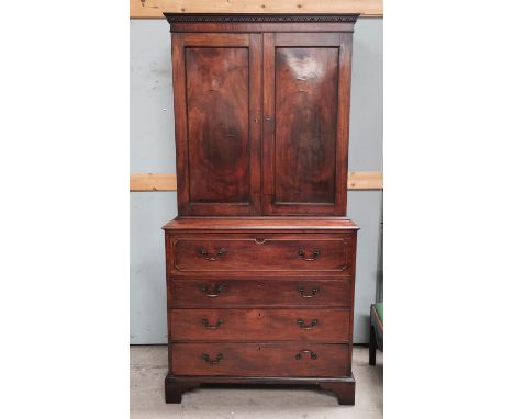 A George III mahogany secretaire/cabinet, the upper section with twin figured panelled doors, the base with fall front, fitte