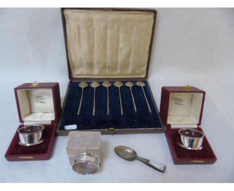 A pair of boxed silver napkin rings plus one other and silver caddy spoon and part set of white metal spoons