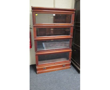 A mahogany Globe Wernicke four tier stacking glazed bookcase, with base drawer