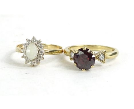 Two 9ct gold dress rings, to include a floral cluster ring with central opal, surrounded by cz stones, and another with raise