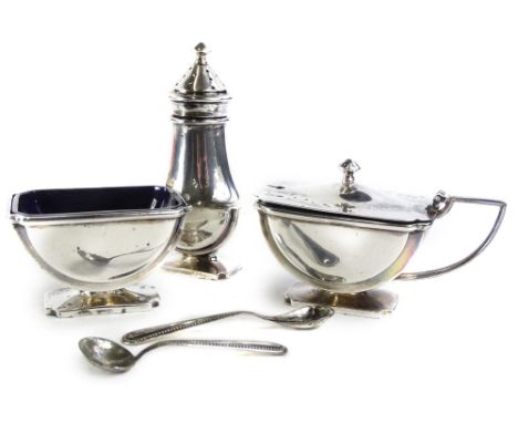 A George V Art Deco silver three piece cruet, comprising pepper pot, mustard pot and salt, to include blue glass liners, Birm