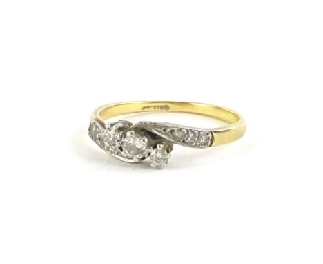 An 18ct gold diamond set twist ring, the claw set central tiny diamonds set in a row, with illusion set tiny diamonds to shou