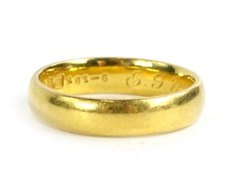 A 22ct gold wedding band, of plain design with engraving to inner band E.G.W-L.B 15-7-22, maker B and Co, 5g.