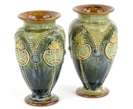 A pair of Doulton Lambeth stoneware vases, decorated in Art Noveau style, with flowers, leaves, etc., on a blue and green mot