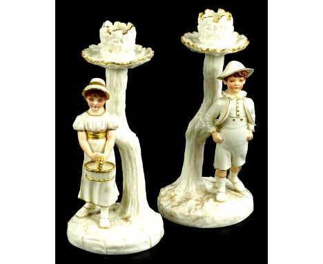 A pair of Royal Worcester porcelain candlestick figures, each applied with a male and female figure, printed mark to undersid