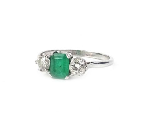 A platinum, emerald and diamond ring, in the Art Deco style, the central rectangular cut emerald in claw setting, flanked by 