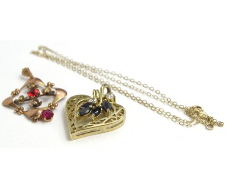 An Art Nouveau pendant and chain, the pendant set with garnets, in floral design with fine link chain, yellow metal stamped 9