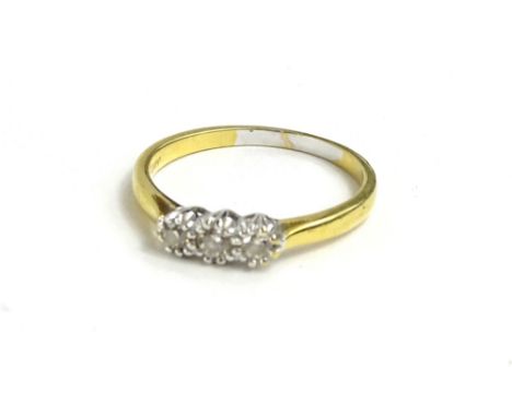 An 18ct gold three stone diamond ring, set with three illusion set tiny diamonds, with pierced ring head, 3.1g.