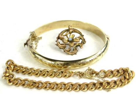 Three items of jewellery, to include a silver floral bar brooch set with central opal, a silver gilt hinged bangle, a brass c