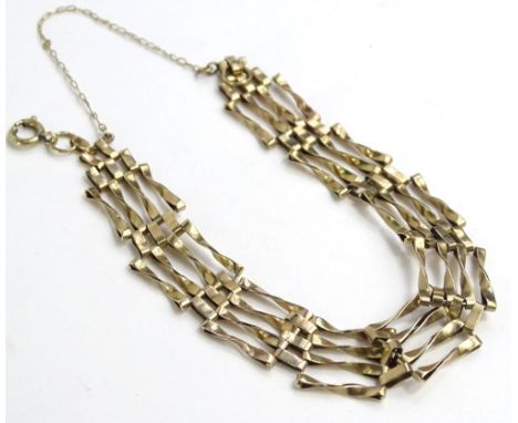 A 9ct gold gate bracelet, of four bar design, with safety chain lacking padlock, 7.5g.