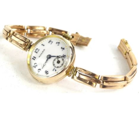 A ladies 9ct gold Rolex wristwatch, circa 1924, with white enamel dial, seconds dial blue hands, on later gold expanding stra