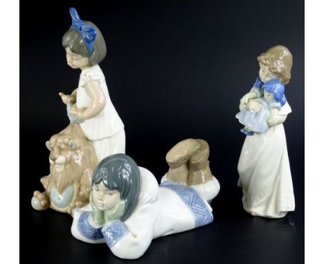 A Nao porcelain figure of an Eskimo girl lying down, boxed, and a figure of a girl with a doll, and a figure of a girl with a