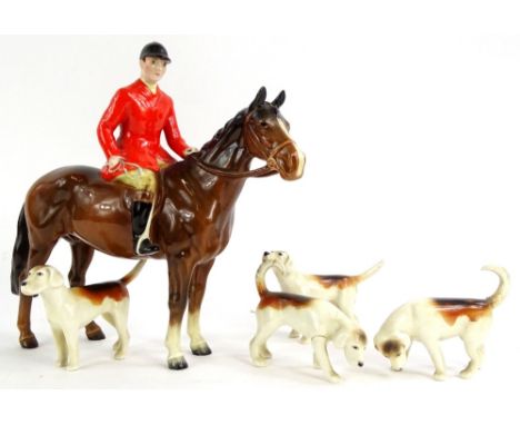 A Beswick ceramic model of a huntsman on a brown horse, and four hounds. (AF)