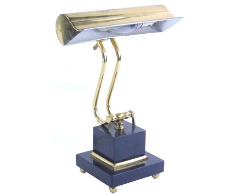 An adjustable brass desk light, on a black polished slate or quartz base, 23cm W.