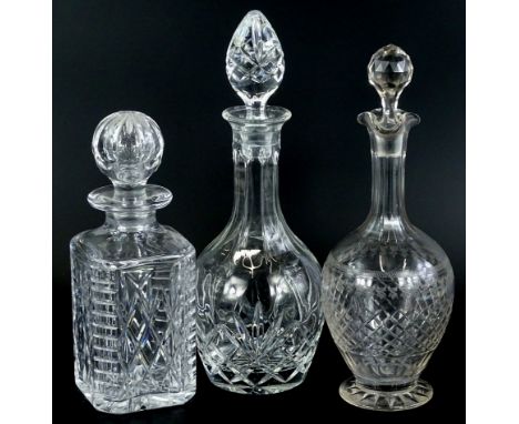 An Edwardian cut and etched decanter and stopper, and two crystal decanter and stoppers. (3)