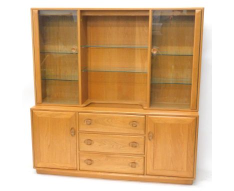 An Ercol blonde elm dresser, the raised back with two glazed doors enclosing adjustable glass shelves, flanking a central rec