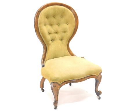 A Victorian walnut show frame nursing chair, with a button back and padded seat on cabriole legs, with castors.