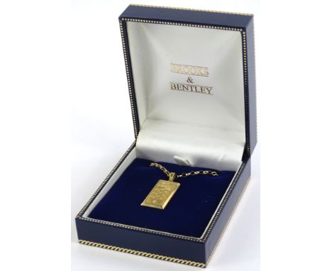 A Brooks and Bentley 9ct gold ingot pendant and chain, the pendant set with crown and three lions and tiny white stone to bot