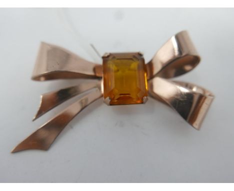 A large vintage, sterling silver and rose gold plated bow brooch centrally set with a stepped-cut, orange-coloured crystal, 4