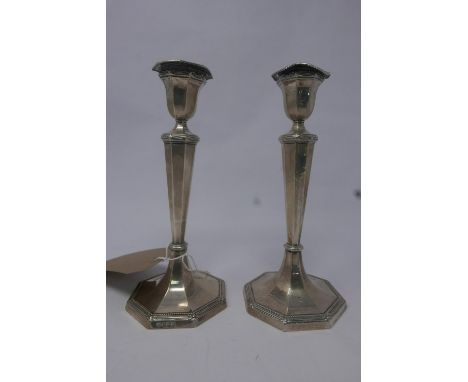 A pair of filled silver candlesticks, raised on octagonal base, by Harrison Brothers &amp; Howson (George Howson), Sheffield 