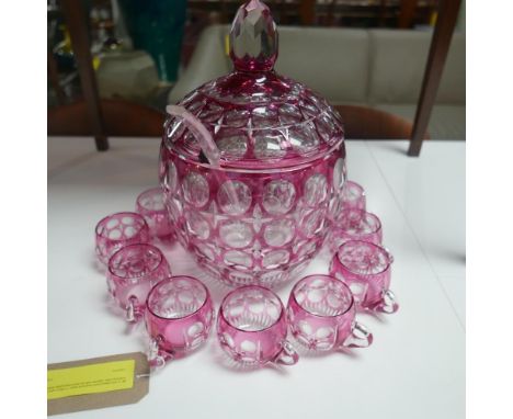 A pink glass punch bowl and cover, H.35cm, with twelve matching cups, together with an associated glass ladle, L.31cm (14) 