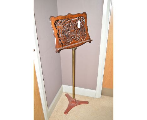 A 19th Century rosewood fretwork music stand, raised on a brass column on a five-form cast iron base.