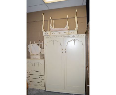 A five-piece cream colour bedroom suite, comprising: wardrobe, millinery cupboard, dressing table, stool, bedside table, and 