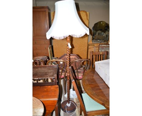 A spiral twist standard lamp with cream coloured flared shade.