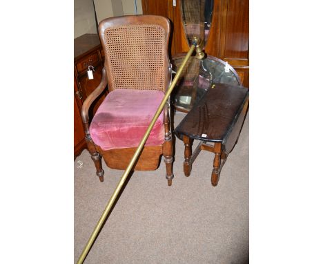 A Victorian commode armchair with cane back and shaped arms, raised on turned front legs; together with a modern oak gateleg 