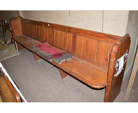 A Victorian pitch pine church pew with panel back, shaped ends and solid seat; together with a carpet strip seat cover and fi