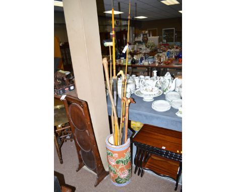A ceramic umbrella receiver containing walking sticks; fishing rod; etc.