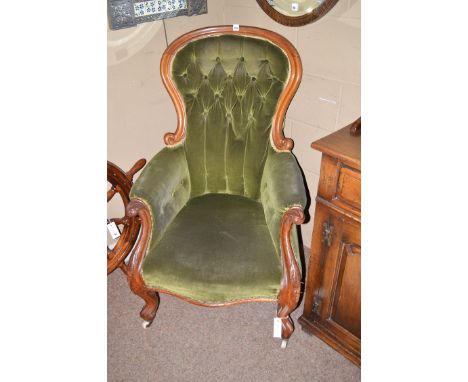 A gentleman's Victorian easy chair with fiddle-shaped back, the seat, buttoned back, and arms upholstered in green velour, ra