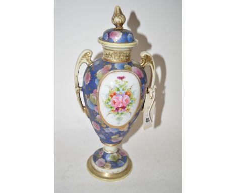 A pair of Noritake two-handled ware shouldered vases and covers, decorative oval panels with sprays of flowers on dark blue a