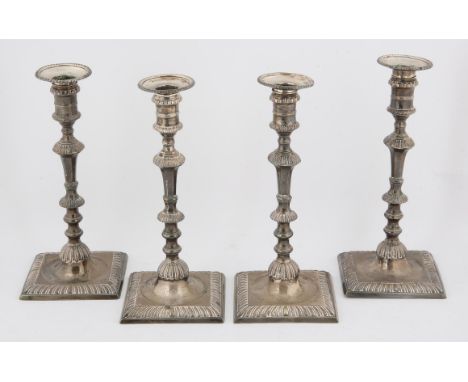 Set of four George III silver candlesticks, the square bases with gadrooned decoration,crested, marks for William Café, Londo