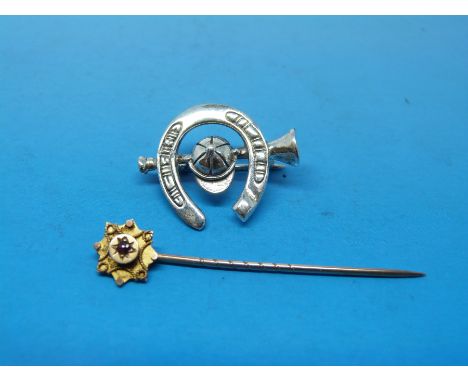 A 9ct gold stick pin set with a ruby and a silver brooch in the form of a horseshoe 