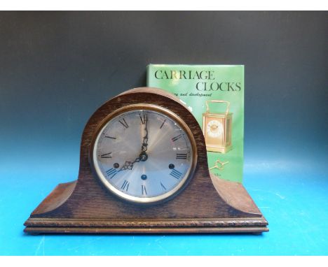 A three train Westminster chime 'Napoleon Hat' cased mantel clock with platform escapement, together with a book on carriage 