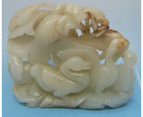 A white celadon jade carving of geese standing upon a rocky outcrop with various small russet inclusions (7.6cm wide)